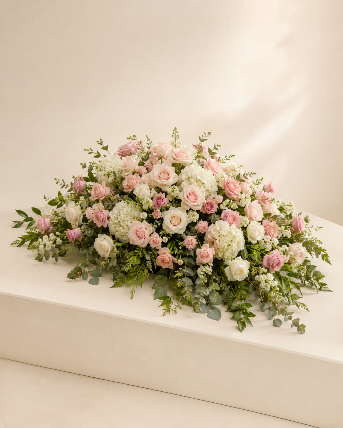Blush Cloud Half-Casket Spray with blush and white roses, pink spray roses, and hydrangeas