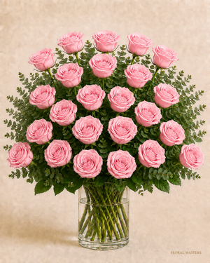 24 soft pink roses with greenery in a clear glass vase