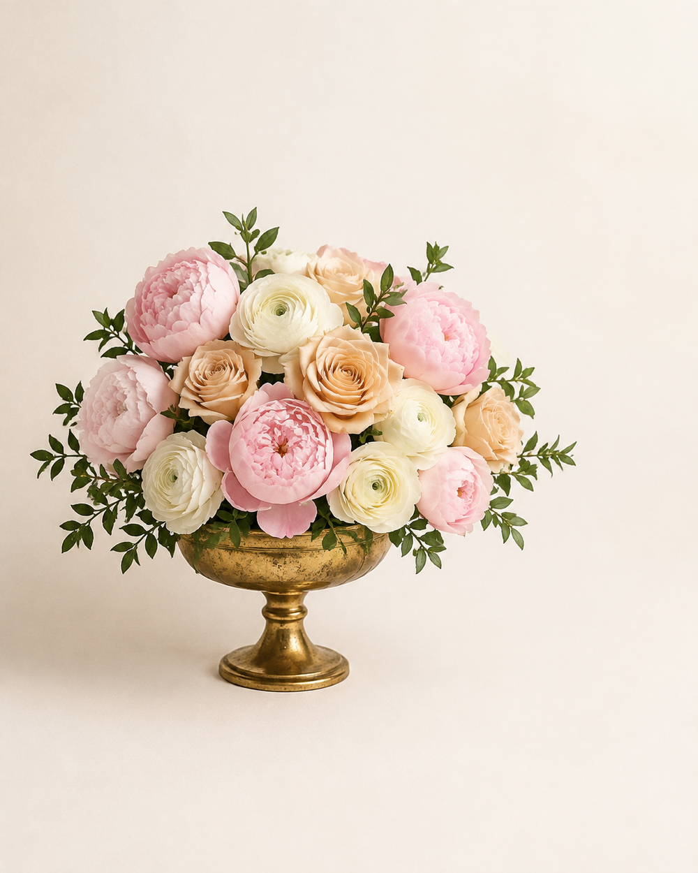 Gilded Peony Salon with blush peonies, champagne roses, and ivory ranunculus in an antique-gold pedestal compote
