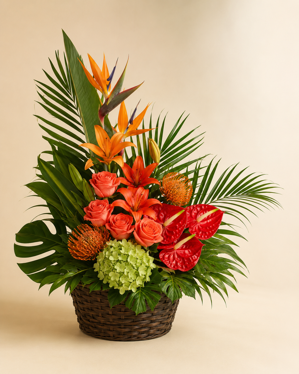 Island Sunset sympathy basket with birds of paradise, coral roses, red anthuriums, orange lilies, green hydrangeia, pincushion proteas, monstera, and palm