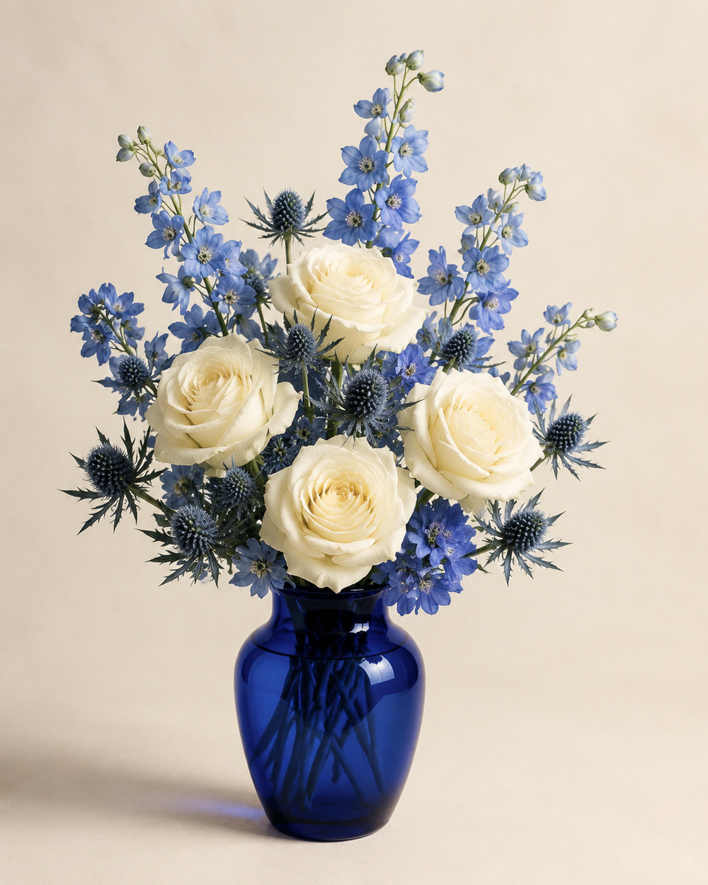 Ivory Blue Rose Gallery in a cobalt-blue glass vase