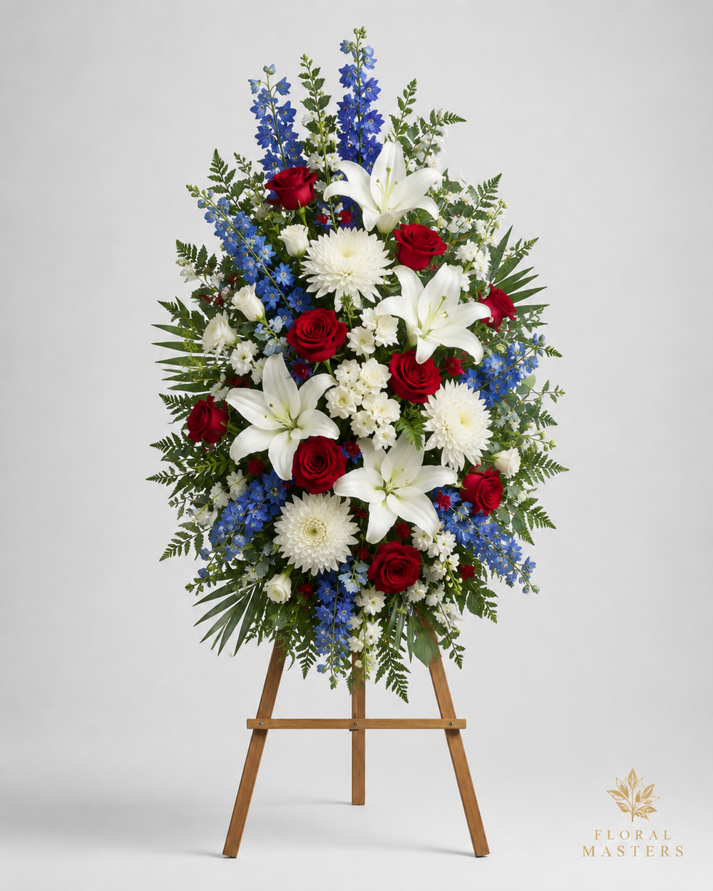 Red white and blue funeral standing spray with roses, lilies and delphinium on wooden easel