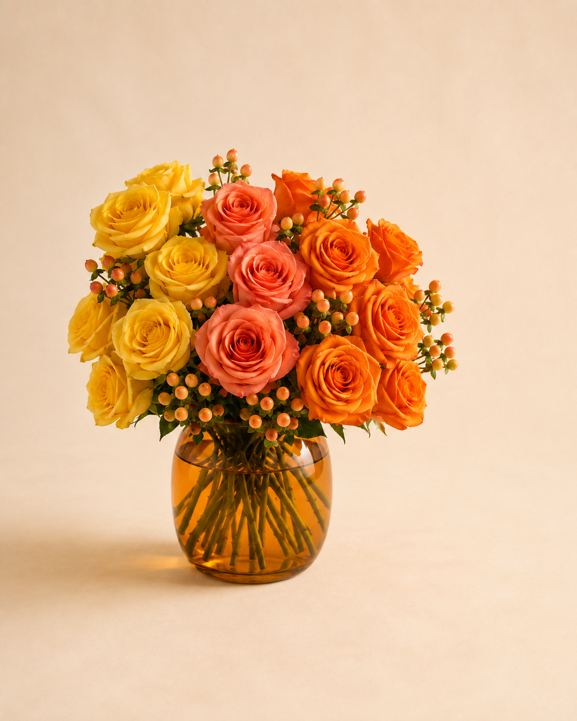 Sunset Rose Spectrum yellow coral and orange roses in an amber glass vase