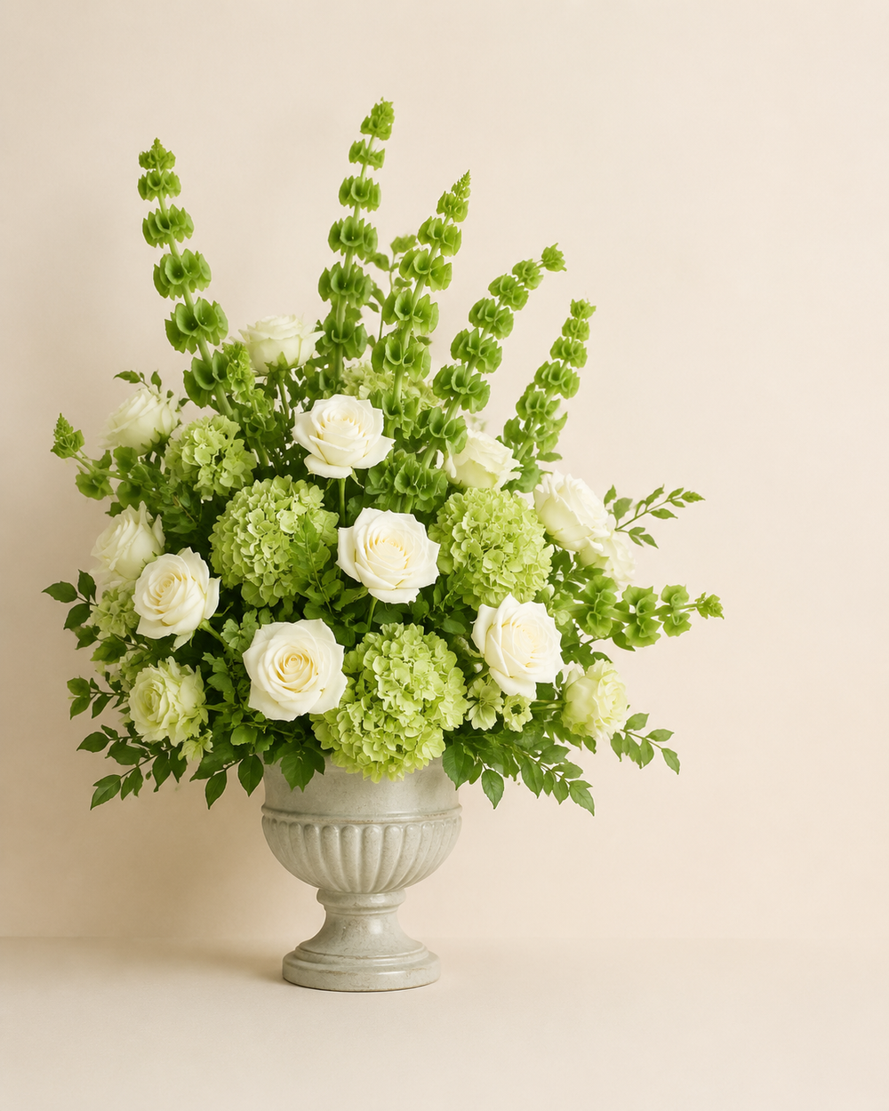 Verdant Pearl Conservatory with green hydrangeas, white roses, and bells-of-Ireland in a pearl-gray ceramic urn